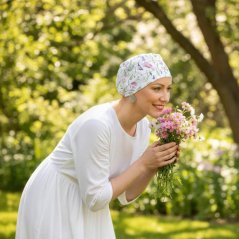 Žena na lúke nosiacia čiapku po chemoterapii Canaver Classic s kvetkovaným vzorom.